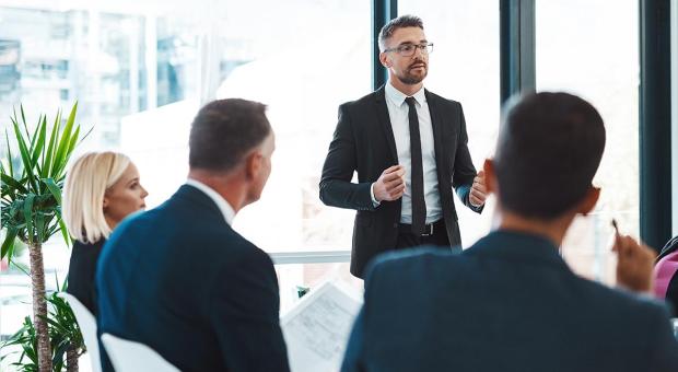 A business person presenting to an audience in a modern office.